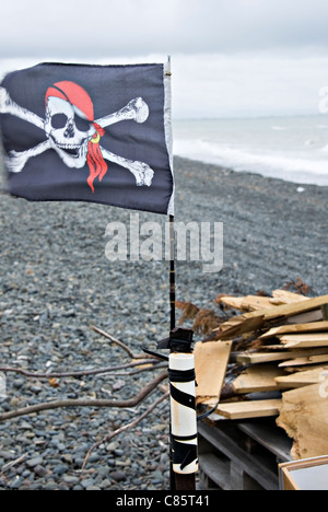 Totenkopf Pirat Flagge fliegt in eine steife Brise am Strand am Cape Kidnappers Hawke Bay Nordinsel Neuseeland Stockfoto