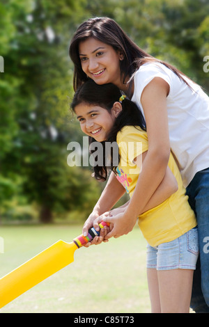 Mutter und Tochter spielen cricket Stockfoto