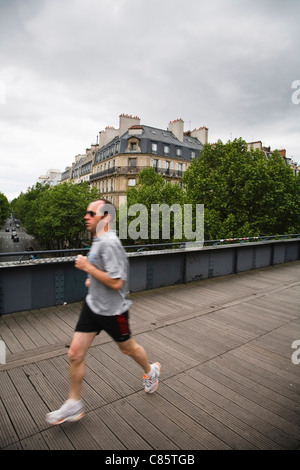 Ein Jogger läuft entlang der Oberseite des Le Viaduc des Arts, Frankreich Stockfoto