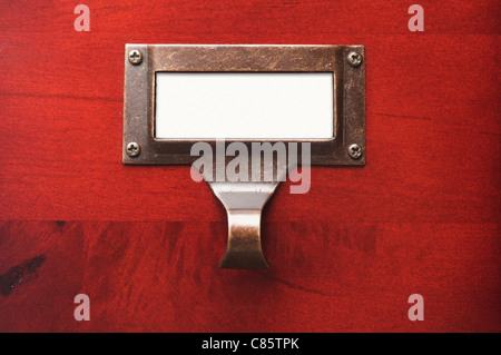 Glänzende Holzgehäuse mit leere Datei Label in dramatisches Licht. Stockfoto