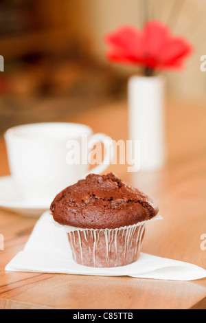 Frühstück-Muffin mit Kaffeetasse in einem gemütlichen Wohnlandschaft Stockfoto