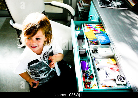 Kleiner Junge am großen Schreibtisch Stockfoto