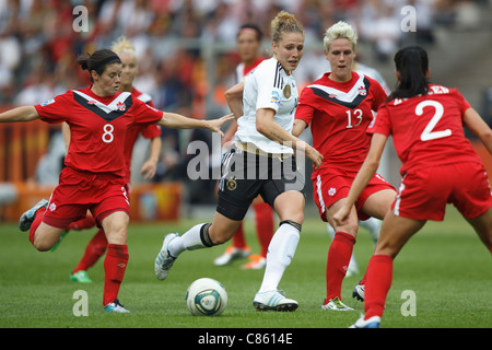 Kim Kulig von Germany (C) ist umgeben von kanadischen Verteidiger während das Eröffnungsspiel der Frauen WM 2011. Stockfoto