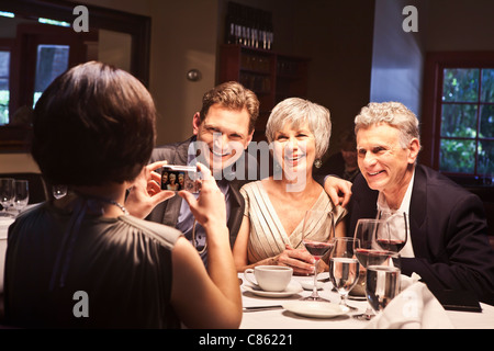 Frau fotografieren Freunde im restaurant Stockfoto