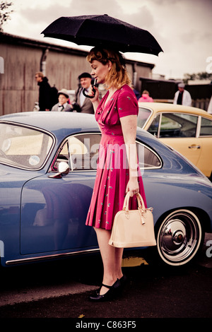 Frauen, gekleidet in historischen Kostümen neben einem Porsche 356 Stockfoto