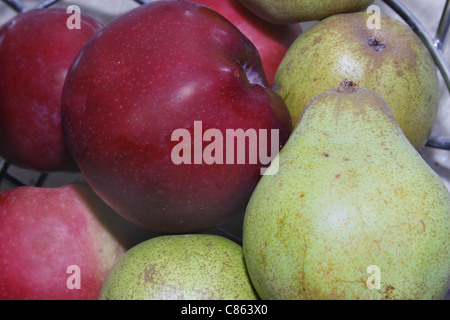 rote Äpfel mit grünen Birnen in einer Obstschale Stockfoto