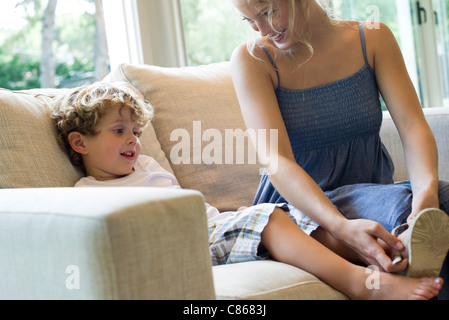 Mutter hilft jungen Sohn Schuhe anziehen Stockfoto