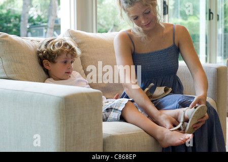 Mutter hilft jungen Sohn Schuhe anziehen Stockfoto