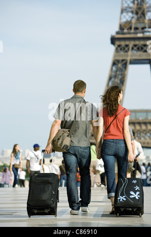 Paare, die mit Rollgepäck in der Nähe von Eiffelturm, Paris, Frankreich Stockfoto