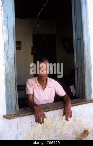 Bundesstaat Bahia, Brasilien. Ältere Frau aus dem Fenster schauen. Stockfoto