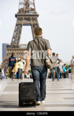 Männliche Touristen zu Fuß mit Gepäck, Eiffelturm, Paris, Frankreich Stockfoto