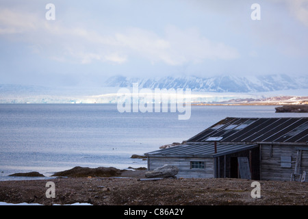 Holzhütte Kongsfjords, mit Gletscher im Hintergrund an der internationalen wissenschaftlichen Forschungsbasis von Ny Alesund, Svalbard. Stockfoto