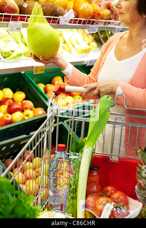 Ältere Frau mit frischem Gemüse in Warenkorb in der Nähe von Stockfoto