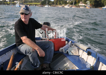 Ein Mann in seiner Mitte der 60er Jahre auf seinem Boot verlässt gerade Falmouth Stockfoto