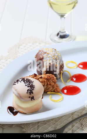 Cremeschnitten mit rosa und Schokolade Zuckerguss und Streusel Stockfoto