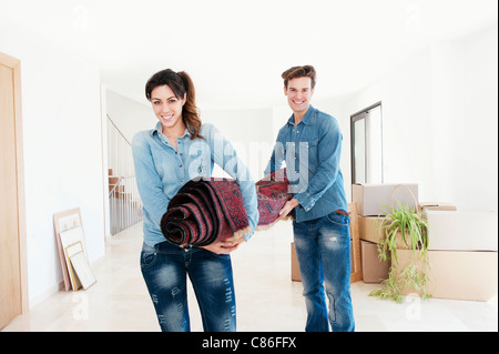 Paar mit Teppich im neuen Zuhause Stockfoto