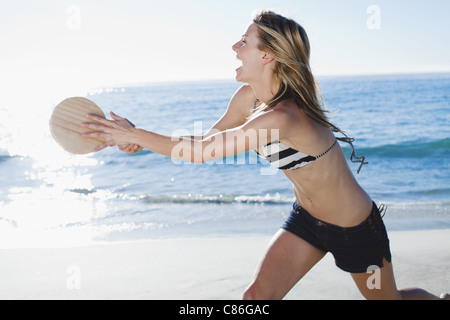 Frau spielt Tennis am Strand Stockfoto