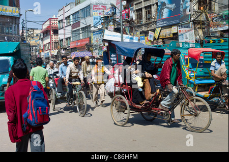 Schuljunge in einheitlichen Schulleitern zur Schule entlang der belebten Straße Chawri Bazar in Alt-Delhi, Indien Stockfoto