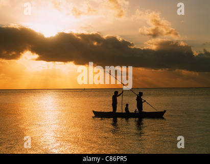 Familie im Auslegerkanu spearfishing auf Insel Aitutaki Lagune auf den Cook Inseln bei Sonnenuntergang Stockfoto