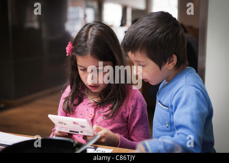 Geschwister, die zusammen auf einem DS zu spielen Stockfoto