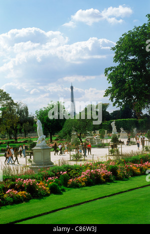 Blumen und Statuen in den Jardin Des Tuileries in der Nähe von Palais du Louvre in Paris mit Eiffelturm und Touristen am Wege Stockfoto