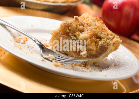 Halb gegessen Apfelkuchen Scheibe mit Krümel-Topping und Gabel. Stockfoto