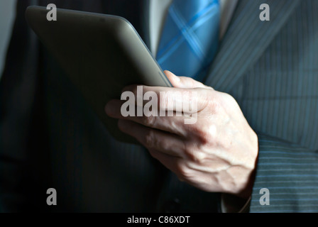Eine Nahaufnahme eines Geschäftsmannes hält einen Tabletcomputer. Stockfoto