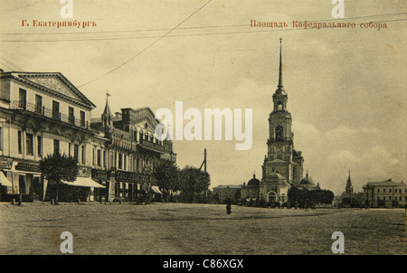 Der Domplatz in Jekaterinburg, Russisches Reich. Schwarz-Weiß-Vintage-Fotografie des russischen Fotografen Veniamin Metenkov vom Anfang des 20. Jahrhunderts, herausgegeben in der russischen Vintage-Postkarte, die von Veniamin Metenkov selbst in Jekaterinburg herausgegeben wurde. Die Kathedrale der Kreuzerhöhung auf dem Domplatz wurde nach der bolschewistischen Revolution 1917 abgerissen. Im Hintergrund ist die Kathedrale der Heiligen Katharina zu sehen. Es wurde auch zerstört. Text auf Russisch: Jekaterinburg. Cathedral Square. Mit freundlicher Genehmigung der Azoor Postcard Collection. Stockfoto