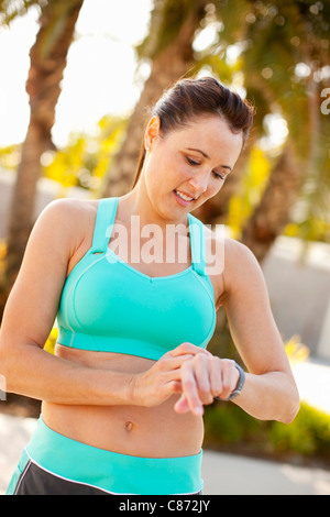 Frau, die Einstellung der Uhr für laufen, Long Beach, Kalifornien, USA Stockfoto