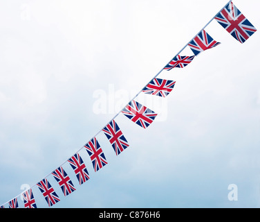 Blick nach oben auf Union Jack, der sich gegen den bewölkten Himmel aufmacht Stockfoto