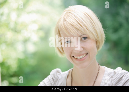 Deutschland, Bayern, Schäftlarn, Nahaufnahme von junge Frau im Park, Porträt, Lächeln Stockfoto