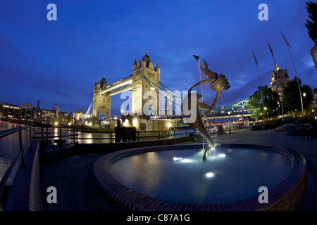 Mädchen mit A Dolphin, Statue von David Wynne, beleuchtet in der Nacht vor der Tower Bridge, London, England, UK, Vereinigtes Königreich, Stockfoto