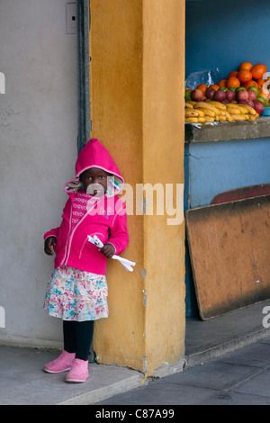 Junge Mädchen stehen durch kleine Obstladen. Amanzimtoti, KwaZulu-Natal, Südafrika. Stockfoto