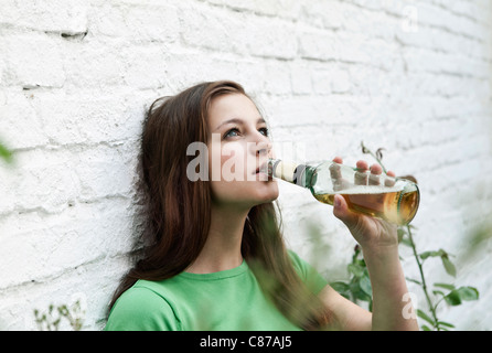 Deutschland, Berlin, junge Frau aus Bierflasche Bier trinken Stockfoto