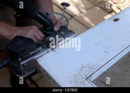 Elektrische Sandpapierschleifmaschine trimmen Tür in Vorbereitung zum Aufhängen. Stockfoto