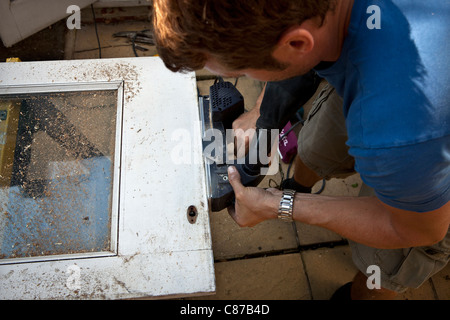 Elektrische Sandpapierschleifmaschine trimmen Tür in Vorbereitung zum Aufhängen. Stockfoto