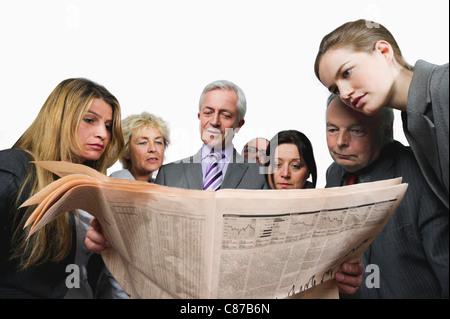 Business-Leute lesen Zeitung vor weißem Hintergrund Stockfoto