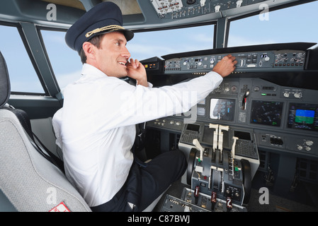 Deutschland, Bayern, München, Pilot mit Handy und Pilotierung Flugzeug aus Flugzeug-cockpit Stockfoto