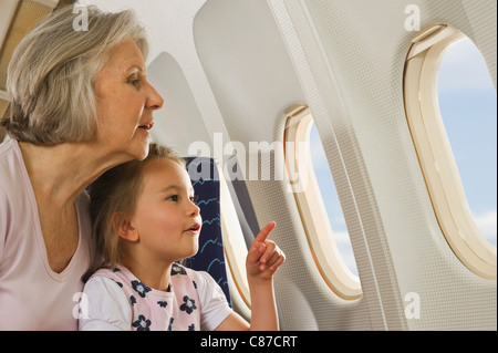 Deutschland, München, Bayern, Senior Frau und Mädchen Blick durch Fenster in Economy-Class-Verkehrsflugzeug Stockfoto