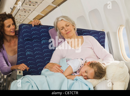 Deutschland, München, Bayern, Senior Frau und Mädchen schläft neben Fenster in Economy-Class-Verkehrsflugzeug Stockfoto