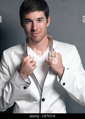 Führerschein und Drucke auf MaximImages.com - Porträt eines jungen lächelnden Mannes in einem eleganten weißen Blazer Stockfoto