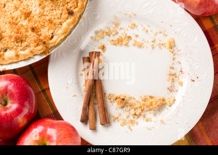 Obenliegende Auszug aus Äpfeln, Zimtstangen, Pie und leeren Teller mit restlichen Krümel in rechteckigen Kopie Raum gelöscht Stockfoto