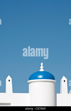 Blauer Turm Dach- und Belüftung Schornsteine auf ein weißes Gebäude gegen strahlend blauen Himmel. Stockfoto