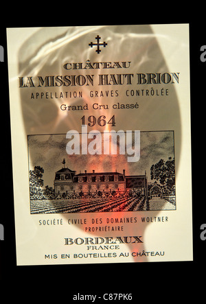 La Mission Haut Brion Wein Glas wirbelnden Schatten fallen auf dem Aufkleber des Chateau La Mission Haut Brion 1964 Grand Cru Rotwein Graves Bordeaux Frankreich Stockfoto