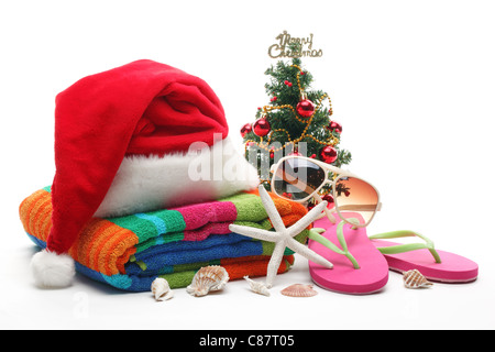 Weihnachtsmann-Mütze und Weihnachtsbaum mit Strand-Accessoires auf weißem Hintergrund. Stockfoto