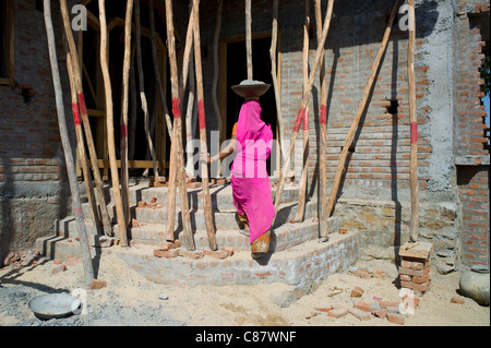 Indische Frau in Sari tragen Zement während der Arbeit auf der Baustelle am Khore Dorf in Rajasthan, Nordindien Stockfoto