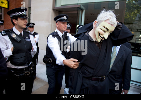 Julian Assange von WikiLeaks bei der Demonstration Occupy London 15. Oktober 2011. Hier zu sehen, versucht er durch die Polizeilinien tragen einen schwarzen Umhang, Kapuze und Maske zu bekommen. Sofort wurde er gebeten, die Maske abzunehmen, wo er auf durch, gezogen wurde, in Frage gestellt und veröffentlicht. Stockfoto