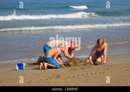 Vater, Sohn und Tochter Sandburgen am Strand von Sidari, Korfu, Griechenland Stockfoto