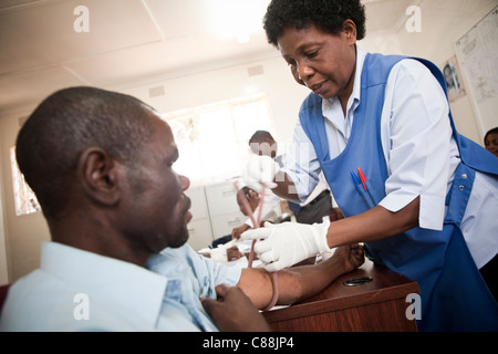 Eine Krankenschwester zieht Blut von einem HIV positiven Patienten in einer Klinik von Catholic Relief Services in Kitwe, Sambia unterstützt. Stockfoto