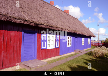 Altes Wohnhaus mit Strohdach. Rot blau gestrichenen Wänden. Schöne architektonische Lösung. Stockfoto